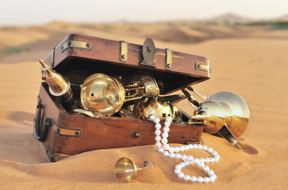 This is an image of a brand-new treasure chest (that's full of brand-new valuables) that's just sitting wide-open on the desert floor.