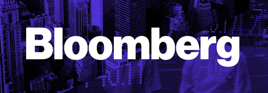 This is an image of the Bloomberg logo placed over a colorful New York background.