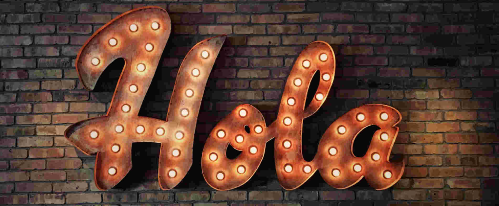 This is an image of an illuminated sign that says "Hola" in cursive.